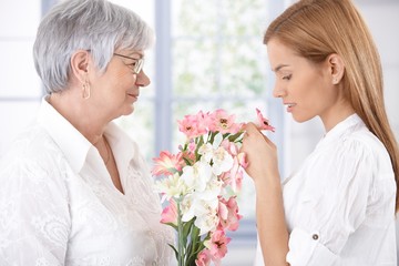 Senior mother and daughter with flowers