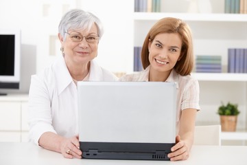 Mature woman and young daughter smiling happily