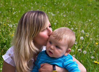 Fototapeta na wymiar young mother kisses her little son