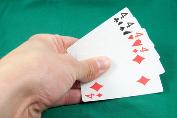 four fours in card hand on green card table