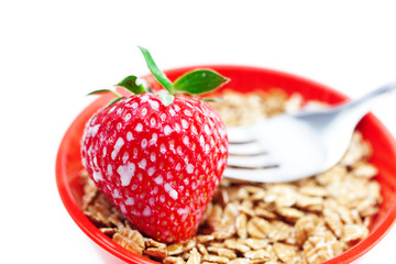 strawberry,milk,fork and wheat in a bowl isolated on white