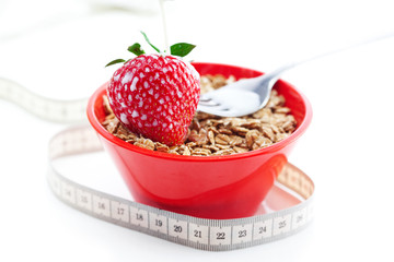 strawberry,milk,fork,measure tape and wheat in a bowl isolated o