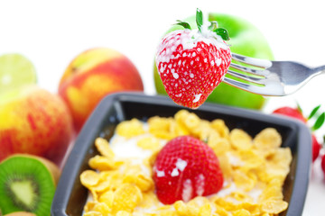 strawberry, peach, apple, kiwi, fork, milk and flakes in a bowl