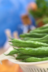 Fresh raw green beans in plastic strainer