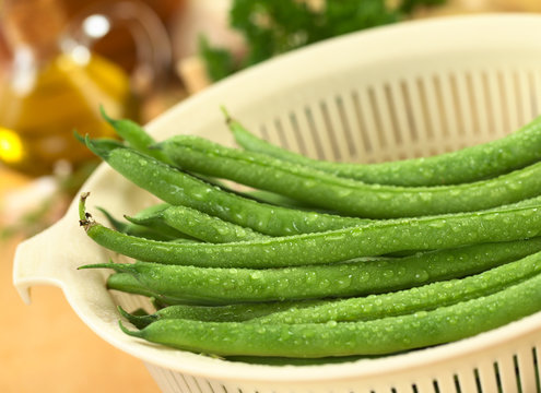 Fresh raw green beans in plastic strainer