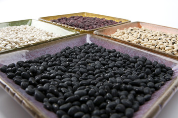 Mixed dried beans in coloreful square dishes