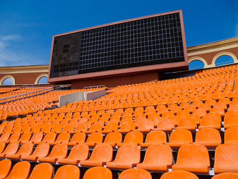 row of seats and score board in football stadium
