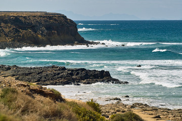 Ocean waves rolls on the rocky beach