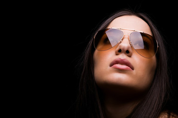 close-up portrait of sexy woman in sunglasses over dark backgrou