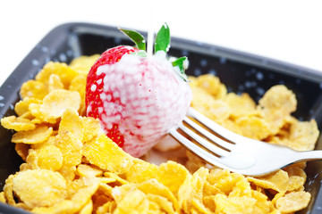 strawberry,milk,fork and flakes in a bowl isolated on white