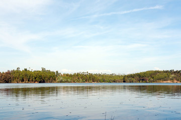 Woods and sky with its reflection in the river