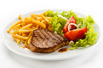 Grilled steak, French fries and vegetables