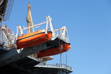 Red lifeboats docked to ship.