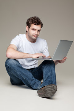 man sitting and holding laptop