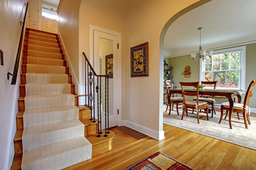 Hallway with large staircase and dinign room