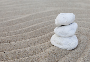 Fototapeta na wymiar pierres zen blanches en équilibre dans le sable