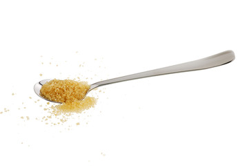 Golden demerara  sugar spilled from teaspoon isolated on white