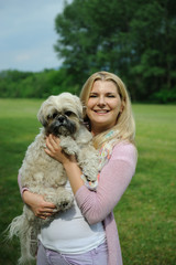 Pretty casual woman with cute little shih tzu dog outdoors in a