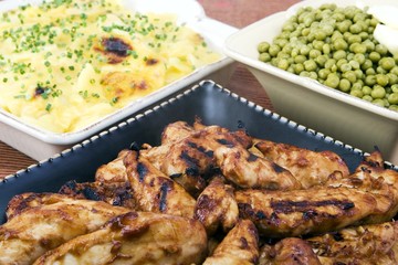 BBQ chicken and scalloped potatoes in ceramic dishes
