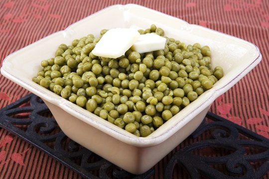 Cooked peas with butter in a ceramic dish