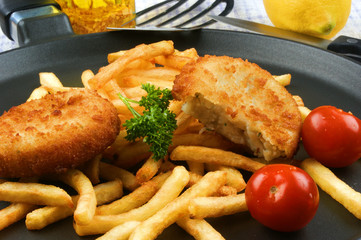 Fischfrikadelle mit Pommes frites auf einer Pfanne