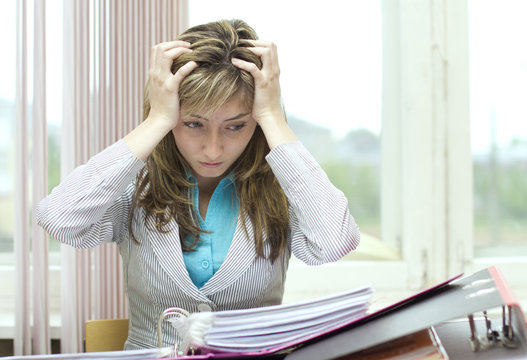 Woman looking perplexed at documents at the office