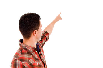 Back view of a young casual man pointing at something over white
