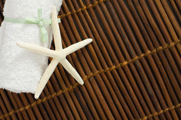 Fototapeta na wymiar Spa or Wellness Background with White Towel on Bamboo mat