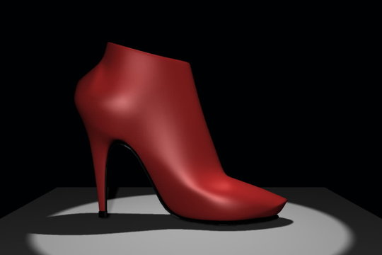 Stivaletto rosso rotante in uno spot di luce