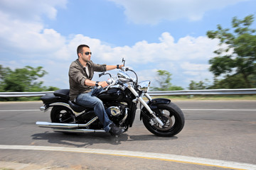 Fototapeta na wymiar Młody mężczyzna, jazda motocyklem na otwartej drodze