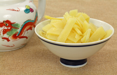 Dish of bamboo shoots next to teapot