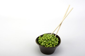 Edamame soy beans in a brown ceramic dish