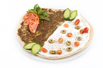 lebanese food of manakish of zaatar & labneh with veggies on top