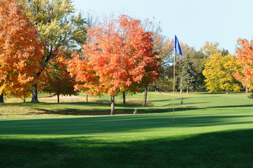 Golf Green and Flagstick with Colorful Fall Leaves
