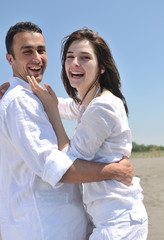 Obraz premium happy young couple have fun on beach