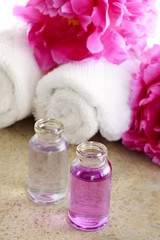Obraz na płótnie Canvas Aroma oil with pink peony flowers and towels