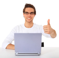 Junger Mann am Laptop zeigt Daumen hoch