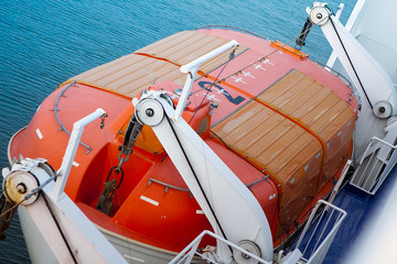 A brightly colored lifeboat on the side of a ferry