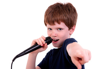 Cute boy with a microphone sings isolated on white, studio shot