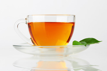 Cup with tea and green leaf