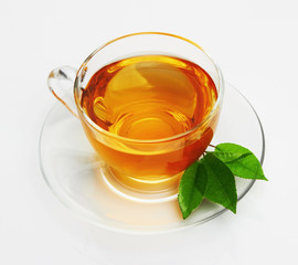 Cup with tea and green leaf