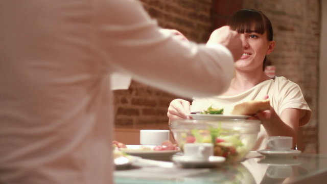 Couple eats meal together, focus on woman