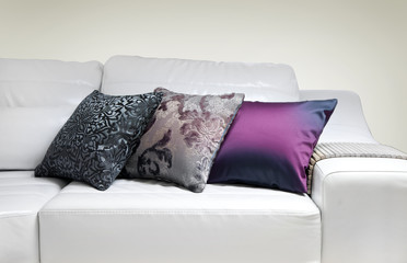 Three decorative pillows on a modern sofa