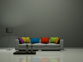 Sofa mit bunten Kissen vor grauer Wand