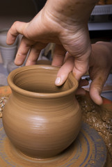 hands of a potter, creating an earthen jar on the circle