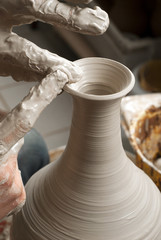 hands of a potter, creating an earthen jar on the circle