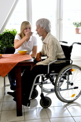 Carer feeding Disabled Woman