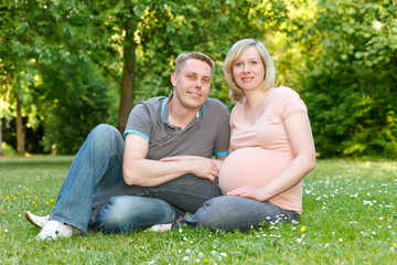 Pregnant couple resting in the park