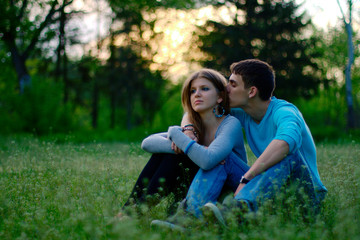 Romantic young couple sitting in field