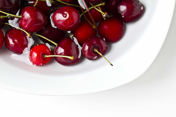 Ciliegie rosse su piatto bianco